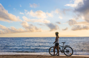 woman with a bicycle on the beach