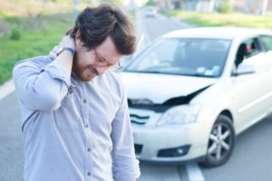 man holding his injured neck after a car accident