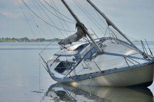 A sailboat capsizes after a boating accident. 