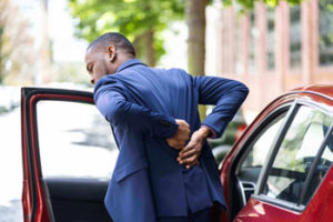 man experiencing back pain after a car accident